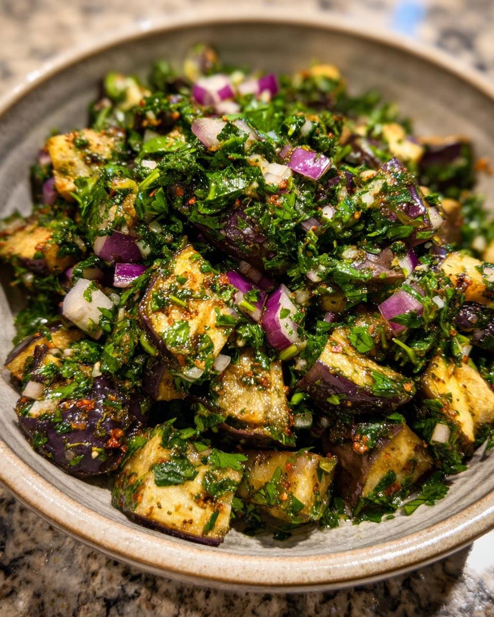 Close-up of Mediterraner Auberginen-Salat mit Petersilie, featuring eggplant, red onion, and parsley.