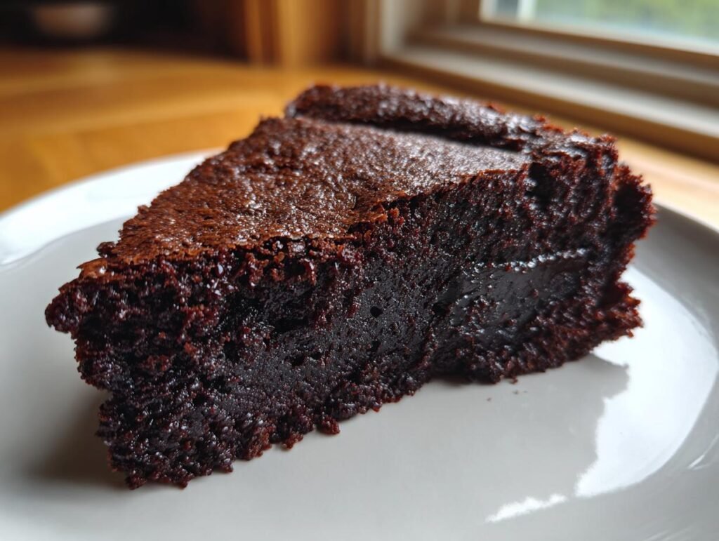 A slice of Mehlfreie Brownies mit griechischem Joghurt on a white plate, showcasing its rich, moist texture.