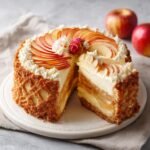 A beautifully decorated Apfelkuchen mit Vanillepudding, featuring apple slices and cream.