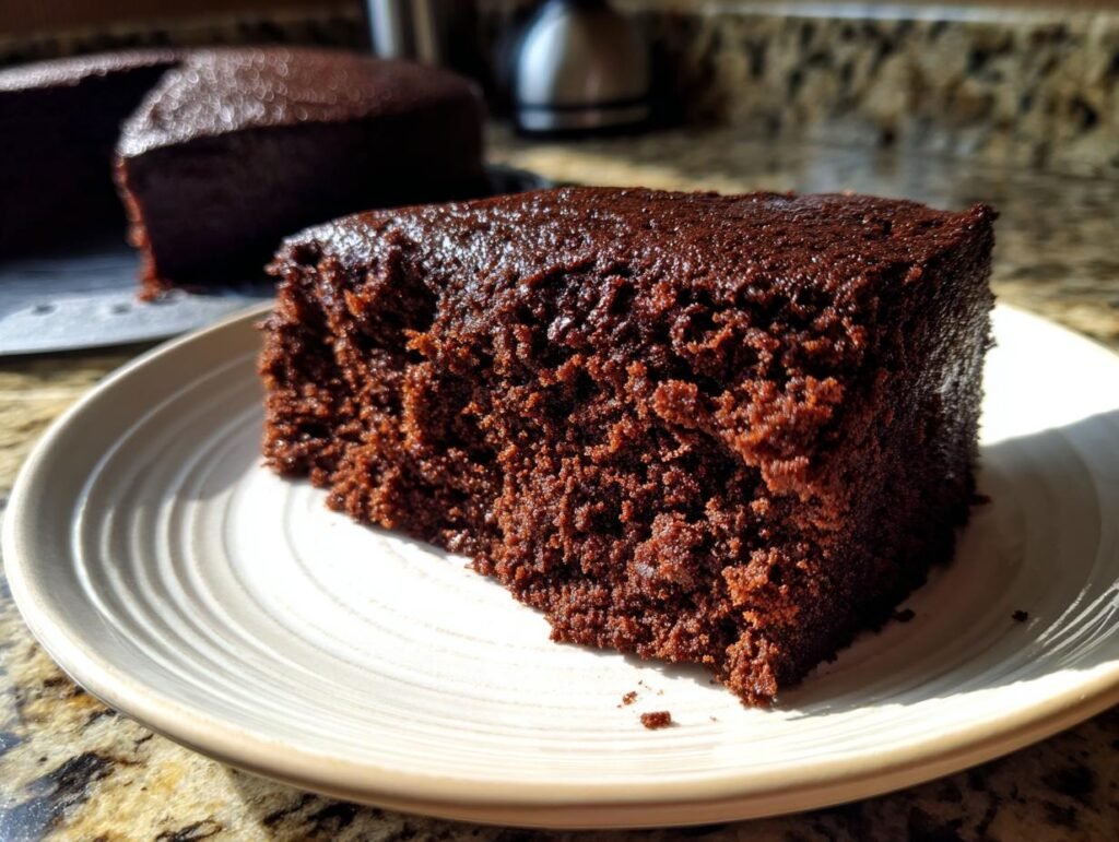 A slice of the Bestes Schokokuchen Rezept, a rich and moist chocolate cake, served on a plate.
