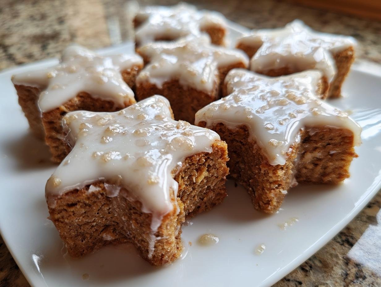 Close-up of Saftige Zimtsterne, soft German cinnamon star cookies with a sweet glaze, on a white plate.