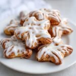 A plate of soft Plätzchen: Weiche Zimtsterne cookies with white icing.