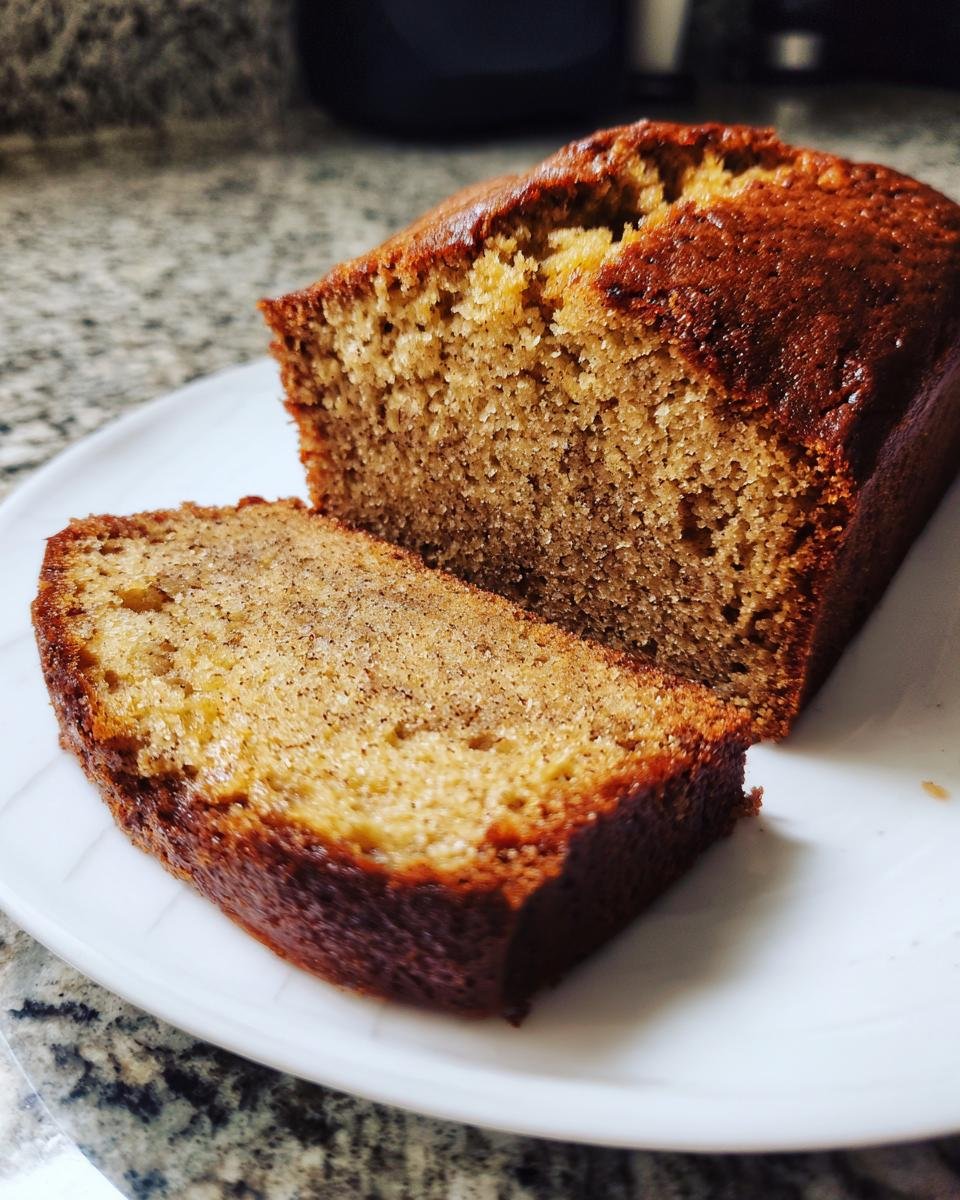 Aufgeschnittener Gewürzkuchen nach Anthony William auf einem weißen Teller mit dunkler Kruste.