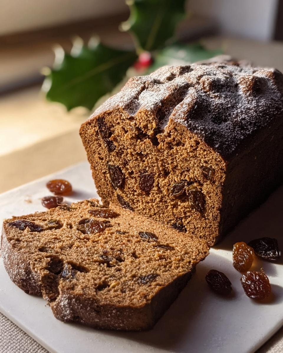 Anschnitt eines festlichen Weihnachtsbrot auf schwedische Art, bestäubt mit Puderzucker und Rosinen.
