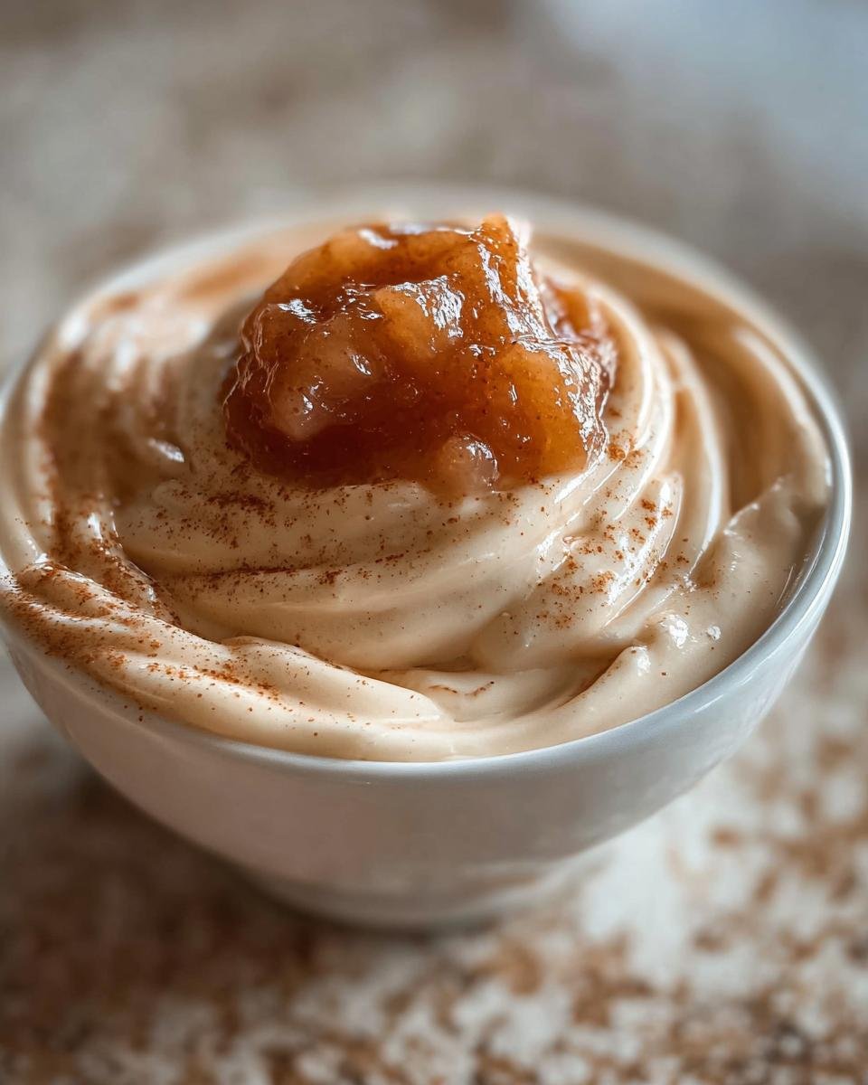 Nahaufnahme einer cremigen Zimtcreme mit Apfelmus und Zimtstaub, ein perfektes Zimtcreme mit Apfelmus.