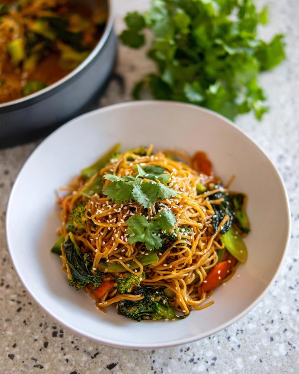 Eine Schüssel mit Schnelle Teriyaki-Nudeln mit Gemüse, garniert mit Koriander und Sesam.